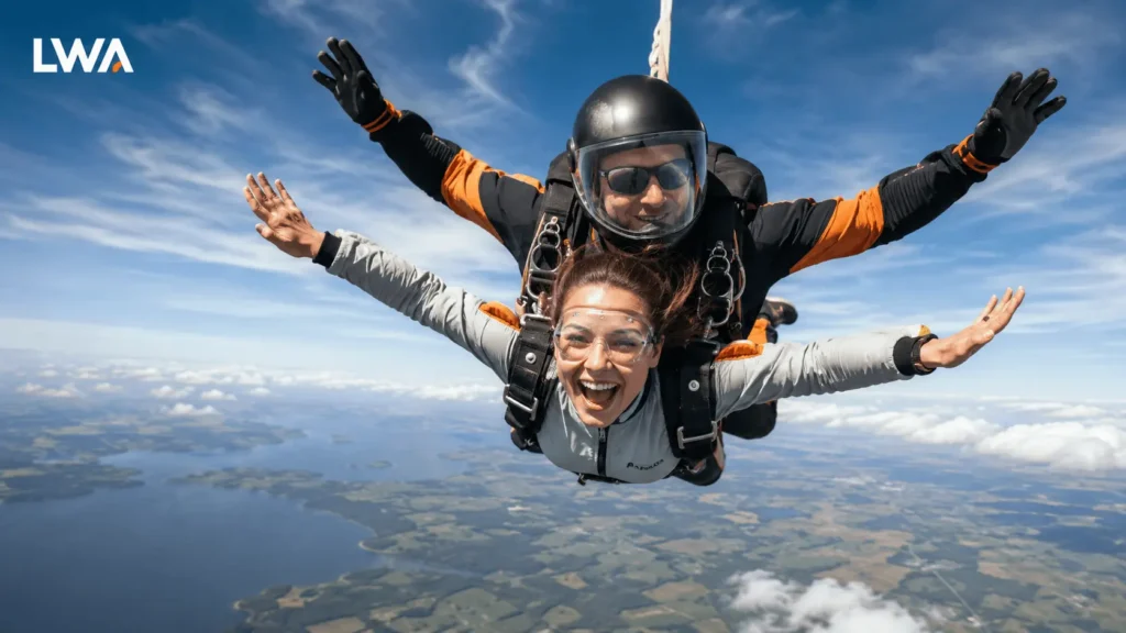 First-time tandem skydiver in freefall with an instructor above a wide landscape.